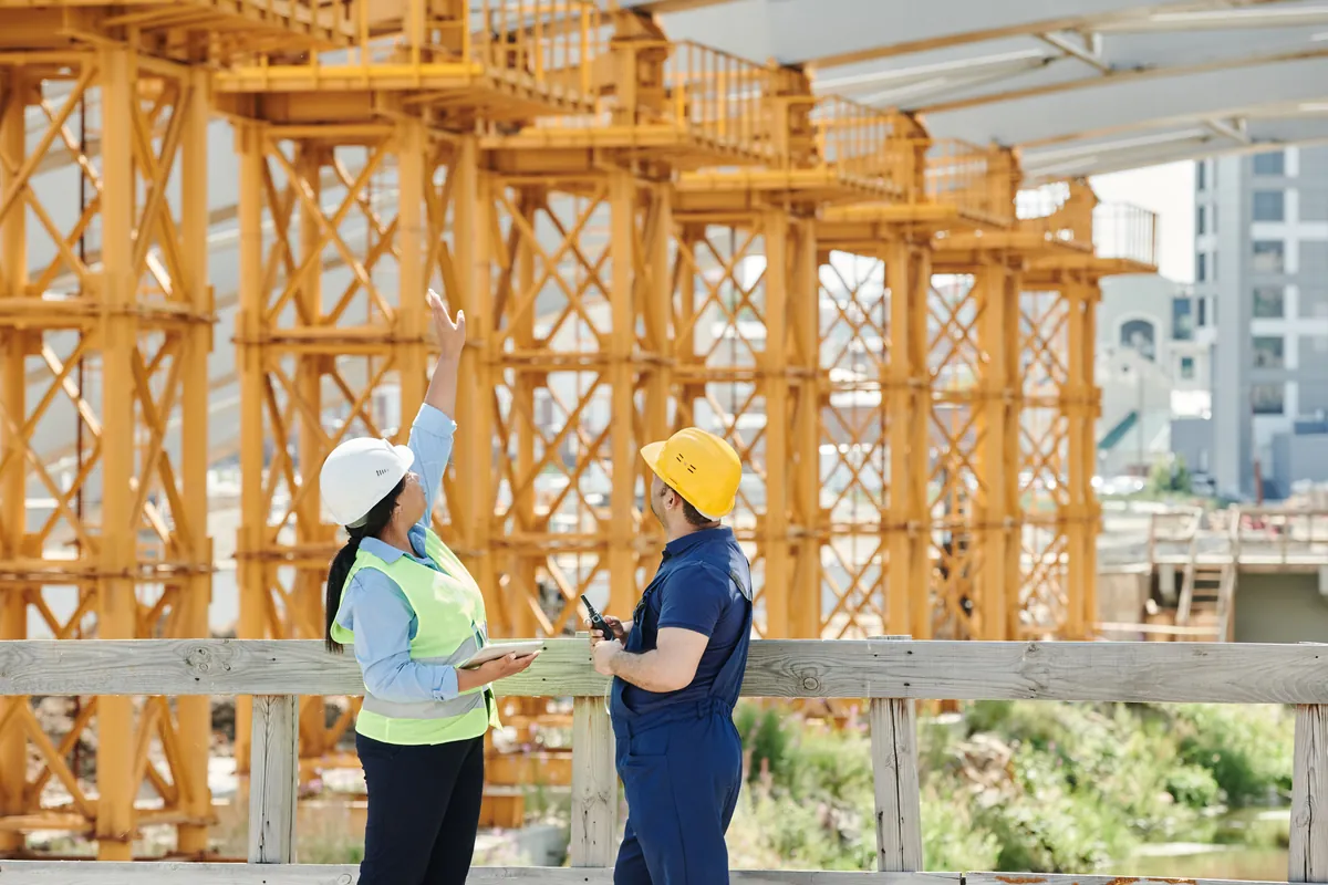 Two engineers on site reviewing a construction project together