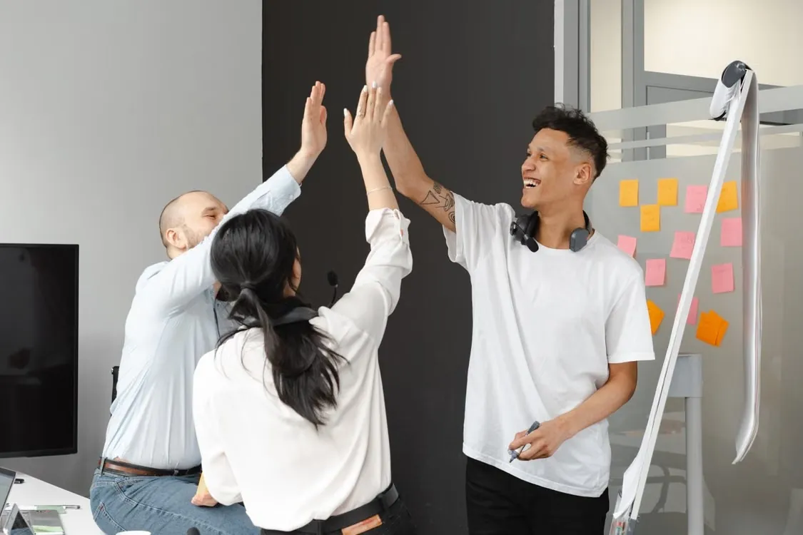 Colleagues high-fiving together in an office